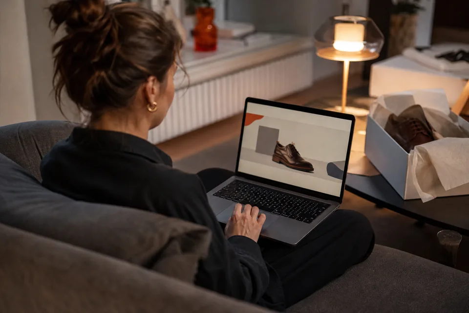 Klientka wraca do koszyka sklepu z butami na laptopie wieczorem w domu